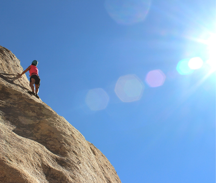 Rock climber scaling a steep cliff face